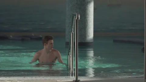Handsome guy resting in the pool Stock Footage 127181325