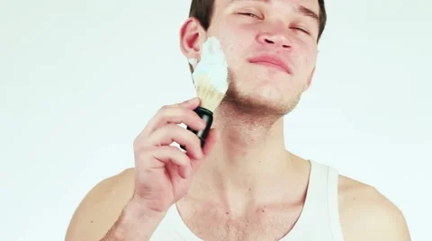 Handsome guy shaves. Man gets shaving foam on his face. Stock-Footage 59311518
