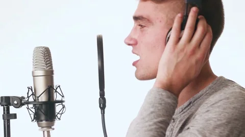 Handsome guy sings in a microphone standing studio headphones. Recording Stock-Footage 58628382