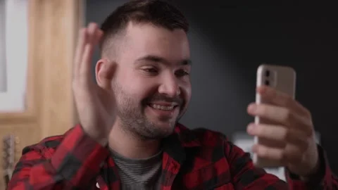 Handsome guy sit on sofa holding smartphone videocall Stock Footage 163703363