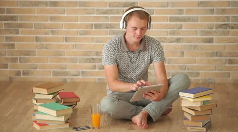 Handsome guy sitting on floor using touchpad looking at camera and smiling Stock Footage 34278305
