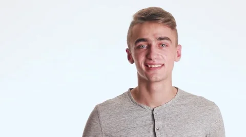 Handsome guy smiles and waves hello. The guy is very nice and amazing. Video stock 58628392