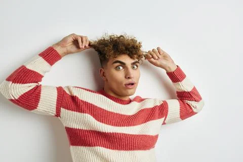 Handsome guy in a striped sweater posing light background Stock Photos