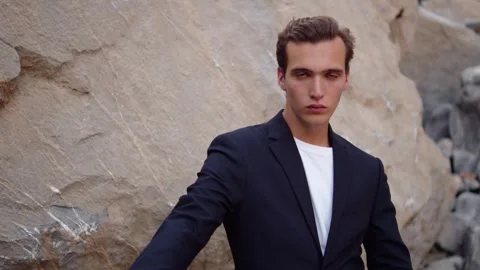 Handsome guy in a stylish suit poses in the mountains. Male fashion model i.. Stock Footage 305589184