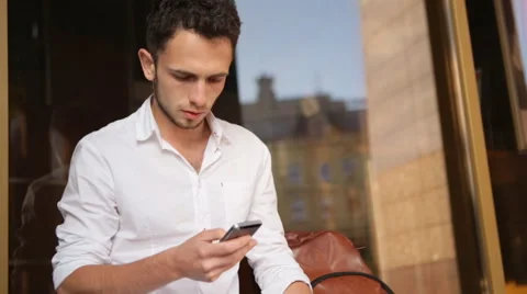 Handsome guy texting on smartphone outdoors Stock Footage 62313023
