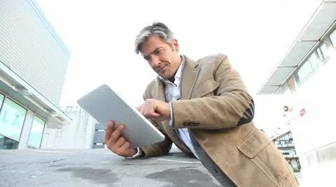 Handsome guy in town using electronic tablet Stock Footage 18194764
