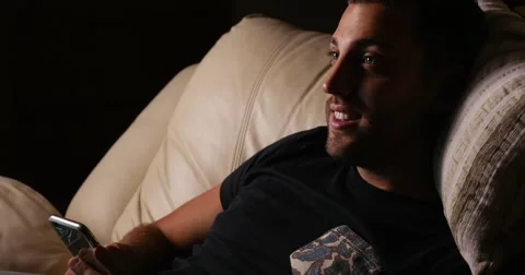 Handsome guy using his mobile on the sofa Stock Footage 62358385