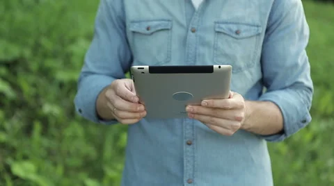 Handsome guy using tablet in park. Close up Video stock 65251540