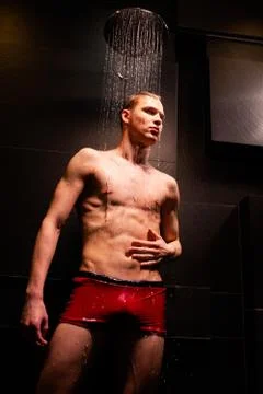 Handsome guy washes in the shower Stock Photos