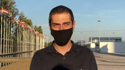 Handsome guy wearing a face mask for the Covid-19 virus and looking the camera Stock Footage 138878960