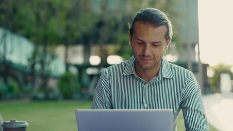 Handsome Guy Working Remotely in the Fresh Air at the Park Using a Laptop. Stock Footage 312731610