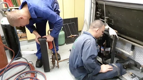 Handsome guys in blue jumpsuits work with modern equipment Stock Footage 116609235