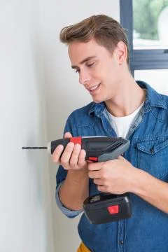 Handsome handyman using a drill Stock Photos