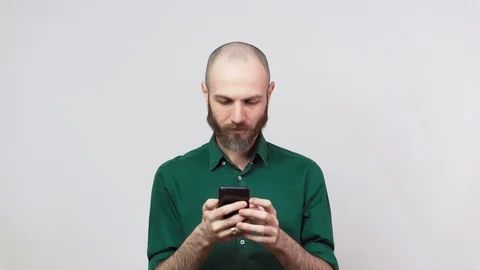 Handsome happy bearded man using mobile phone over white background. Stockbeeldmateriaal 126764572