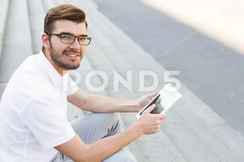 Handsome happy businessman using tablet outdoors, closeup Stock-Fotos
