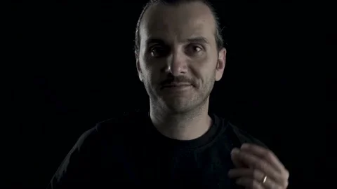 Handsome happy guy is dancing on indoor, black background in studio shot. Tre Stock Footage 133602295