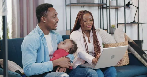 Handsome happy loving young black-skinned man holding his baby on hands sitting Stock Footage 150657682