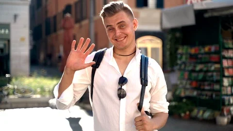 Handsome happy man looking on camera, smiling and waving his hand. Relaxed man Stock-Footage 123709110