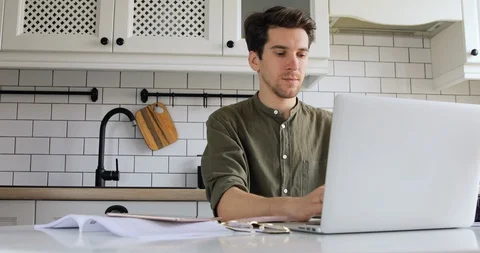 Handsome hipster man sitting in the kitchen and coding html and programming Stock Footage 127643295