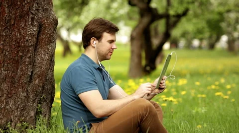 Handsome hipster man talk using his tablet pc on a sunny day Stock Footage 63176768