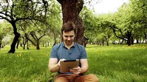 Handsome hipster man using his tablet pc on a sunny day with copy space Stock Footage 63191473