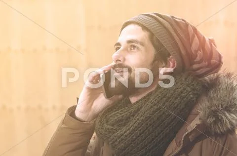 Handsome hipster modern man using smart phone warm tone filter applied Stock Photos