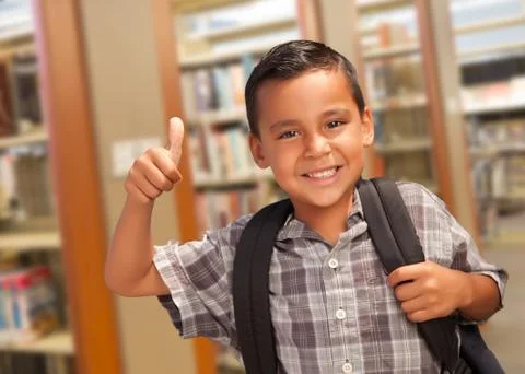 Handsome Hispanic Student Boy with Back Pack and Thumbs Up in the Library. Stock Photos