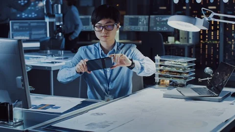 Handsome Japanese Development Engineer in Blue Shirt is Looking at AR Video stock 105342427