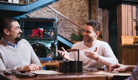 Handsome joyful man explaining something to a friend Stock Photos