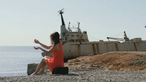 Handsome lady plays with the stones near the old ship Stock Footage