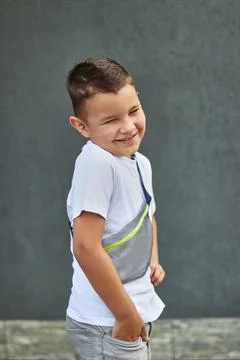 A handsome little boy is posing for the camera, smiling. Carefree childhood. Stock Photos