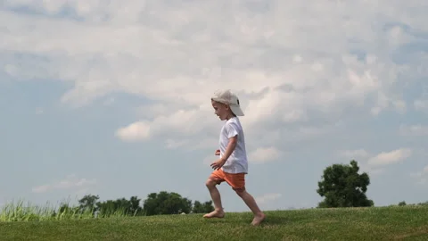 The handsome little boy running barefoot on the grass. slow motion Stock Footage 156536053