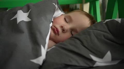 Handsome little boy sleeps in bed under the covers Stock Footage 223661256