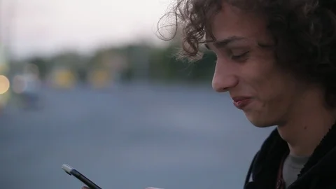 Handsome long haired man shooting video message on telephone outdoors, close-up Stock Footage 97645945