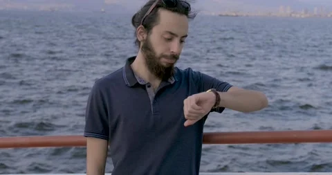 Handsome long haired young boy is waiting girlfriend for dating.He is looking Stock Footage 139301109