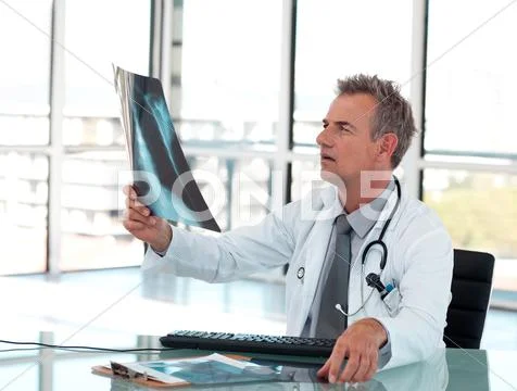 Handsome male doctor examining a x-ray Stock Photos
