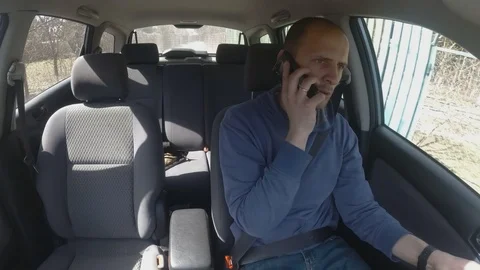 Handsome male driver uses a smartphone while driving a car. Time lapse Stock Footage 106928712