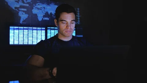 Handsome male hacker programmer works at a computer at night in a data center Stock Footage 102923924