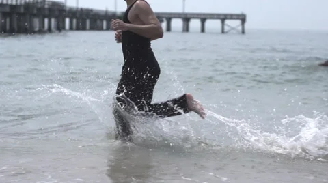 Handsome male model jogging at the beach. slow motion Stock Footage 32019351