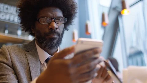 Handsome male in a smart suit checking his phone in a coffee shop Stock Footage 87721359
