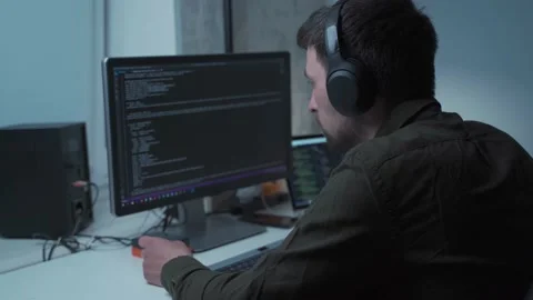 Handsome male software developer programming codes while working behind laptop Stock Footage 153499297