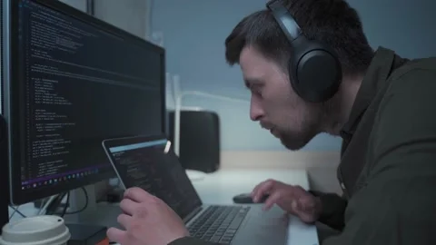 Handsome male software developer programming codes while working behind laptop Stock Footage 153499772