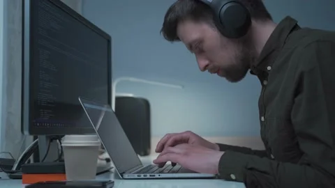 Handsome male software developer programming codes while working behind laptop Stock Footage 153500189