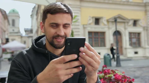 Handsome male student using smartphone. Smiling man making video call mobile Stock Footage 137633475
