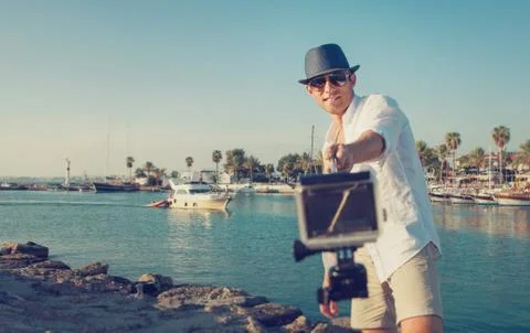 Handsome man with action camera take a selfie photo in the tropical sea bay Stock Photos