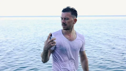 Handsome man and perfume against the sea Stock Footage 314703653