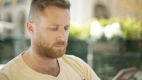 Handsome man answers cellphone in the cafe and chatting with someone, steadycam Stock Footage