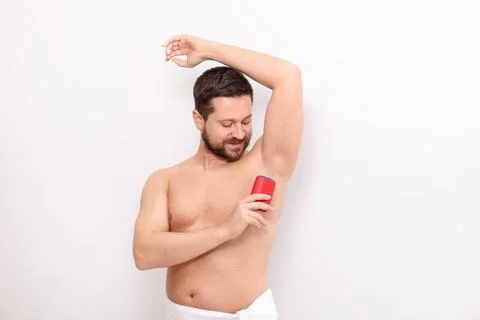Handsome man applying solid deodorant on white background Stockfoto's