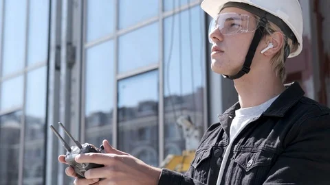 Handsome man architect controlling flying drone for aerial view. Stock Footage 106207116