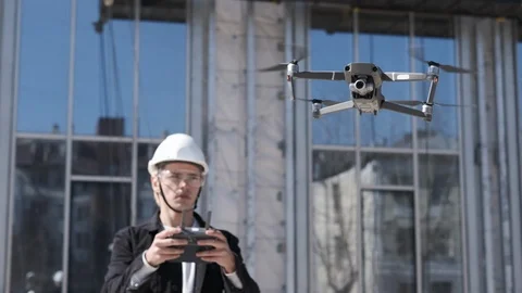 Handsome man architect controlling flying drone for aerial view. Stock Footage 106261978
